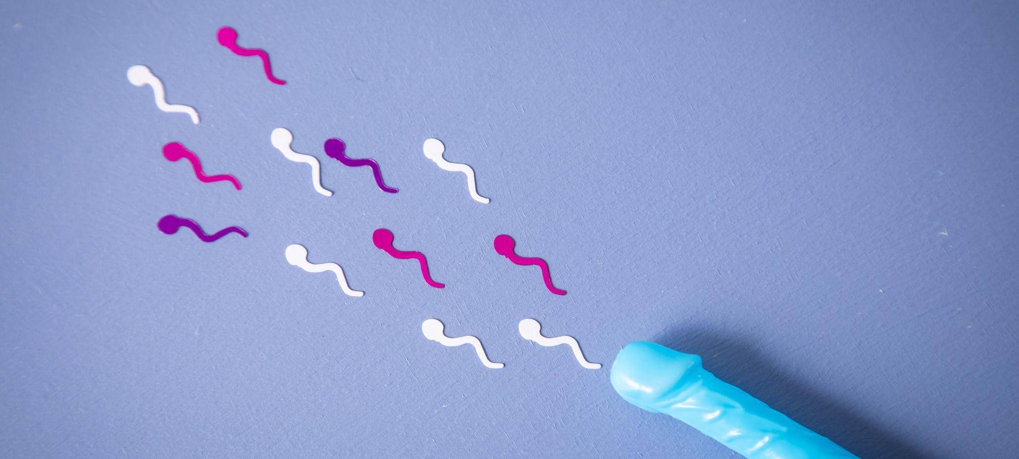 Konfetti in Sperma-Form liegt neben einem Penis-Strohhalm