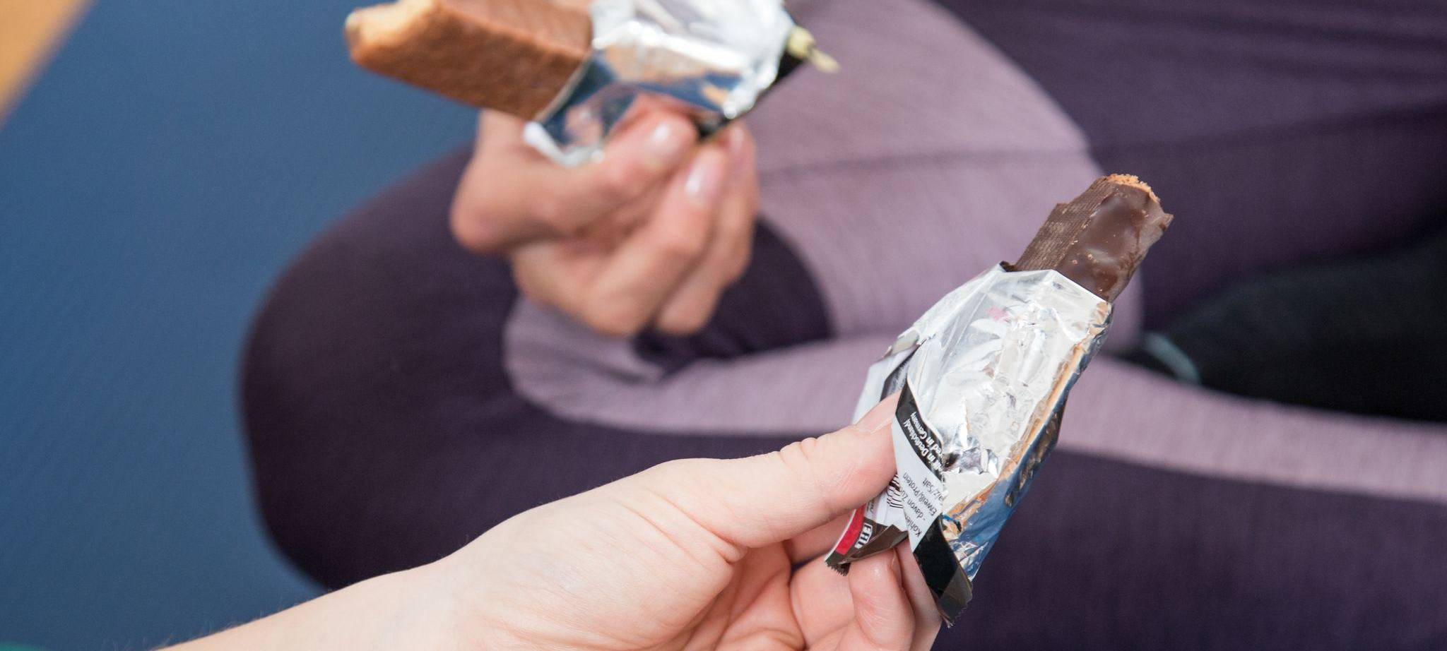 Zwei Personen halten Schokoriegel in den Händen