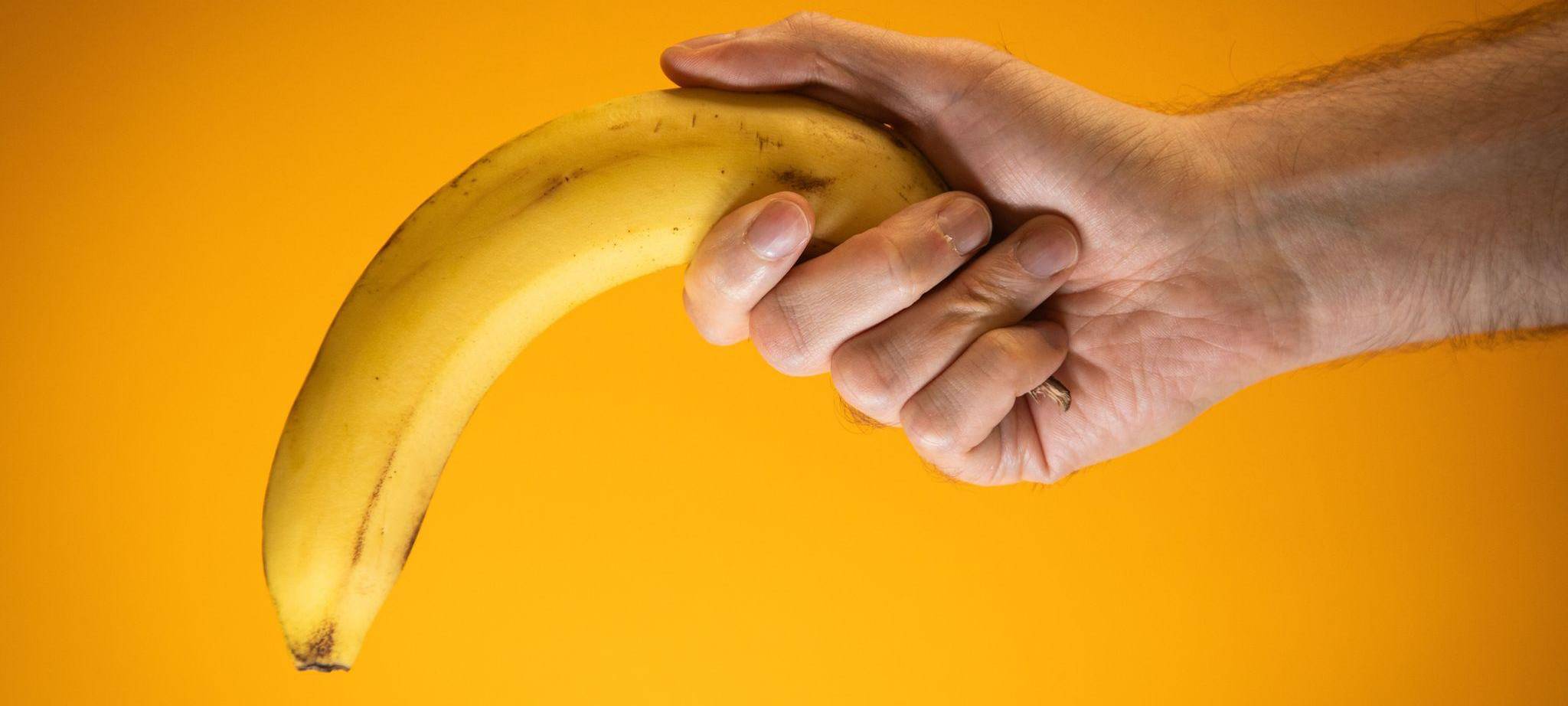 Eine Person hält eine Banane, die nach unten gerichtet ist
