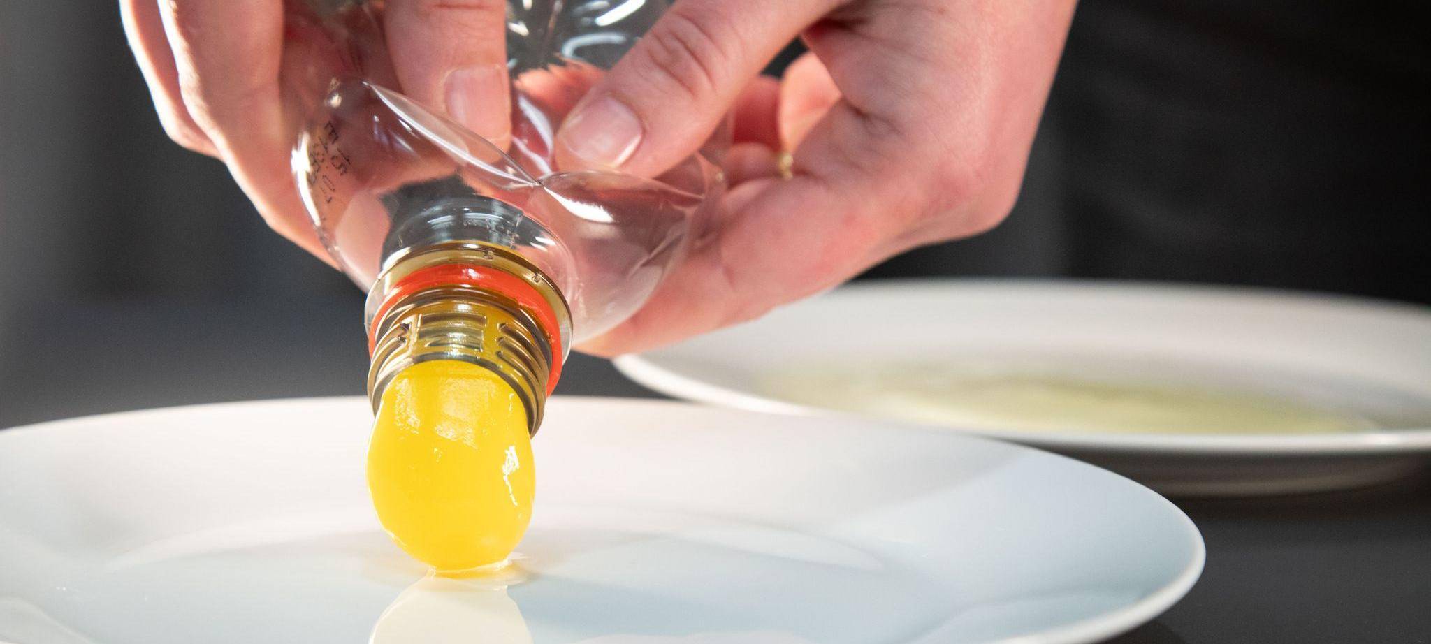 Eigelb wird aus einer Plastikflasche gedrückt