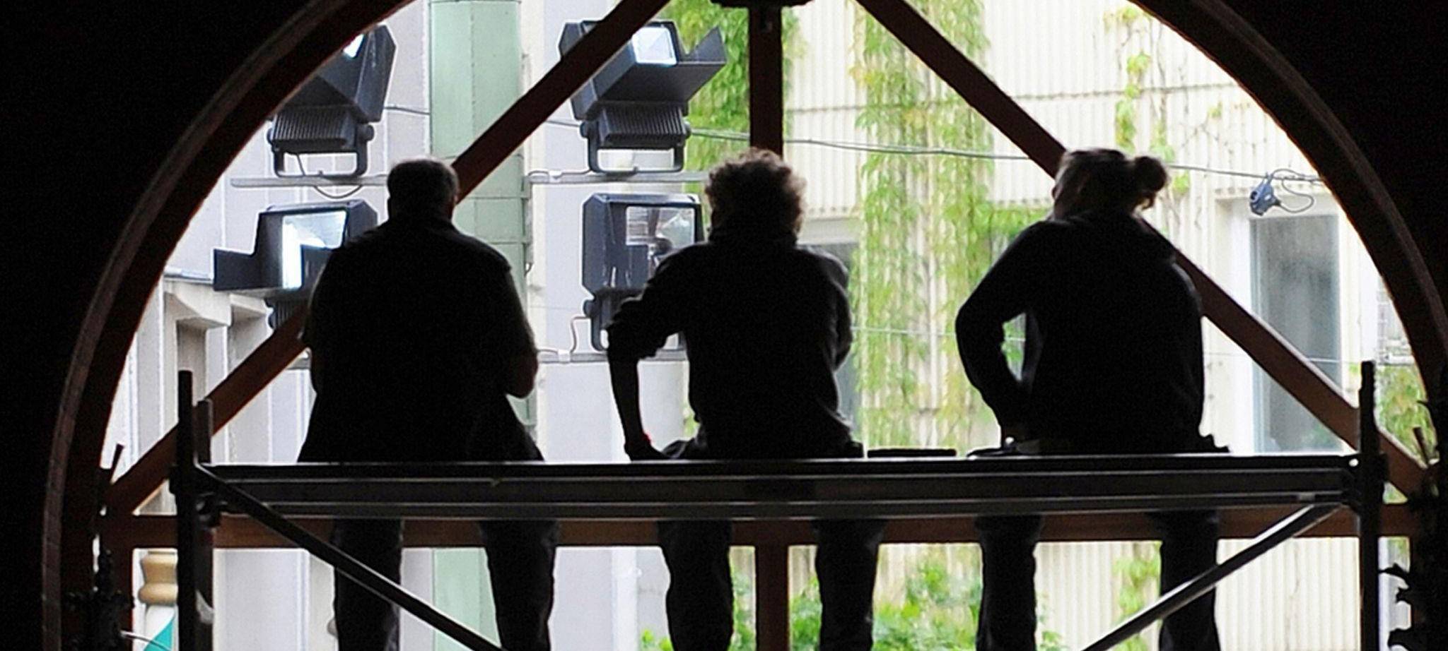 Arbeiter sitzen auf einem Baugerüst