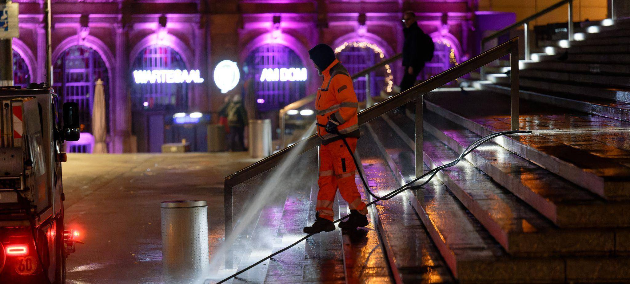 Ein Mitarbeiter der Stadt Köln reinigt eine Treppe