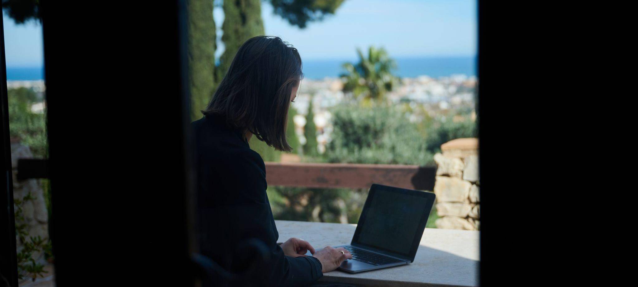 Frau arbeitet im Homeoffice an einem Computer an der Costa Blanca